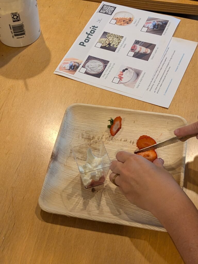 A child slicing strawberries for a yogurt parfait at a Toddlers Love To Cook event