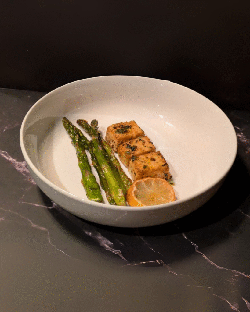 A dinner plate showing oven grilled asparagus and tofu, made by a toddler