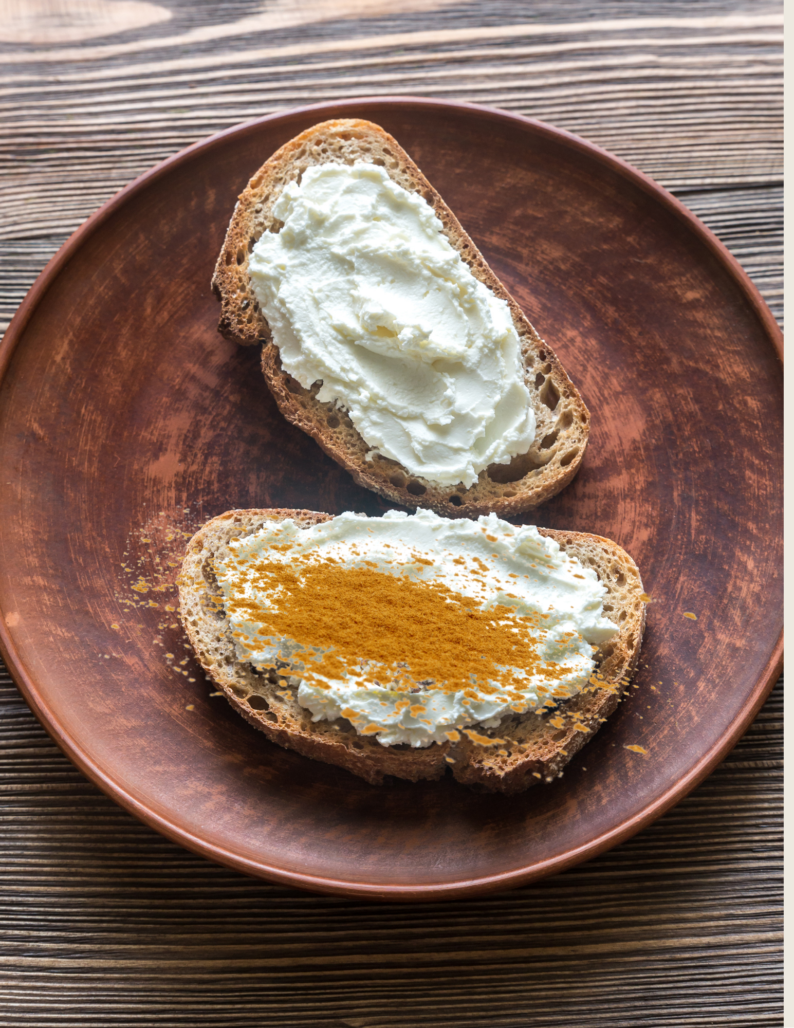 wo slices of toasted bread on a brown plate, topped with cream cheese and sprinkled with cinnamon powder, a simple fall harvest toast recipe for toddlers.